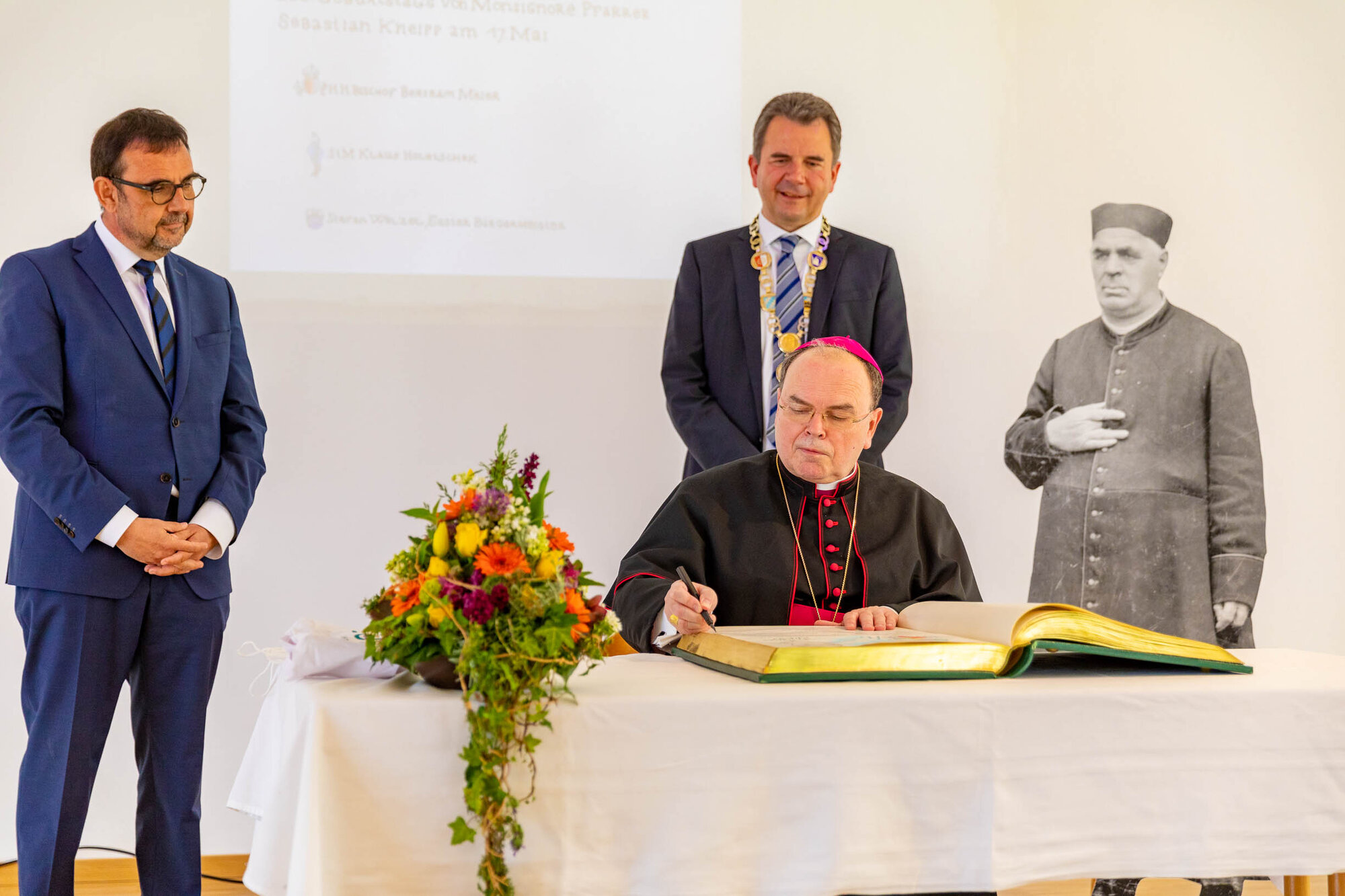 (v. l.) Staatsminister Klaus Holetschek, Bischof Bertram und Bürgermeister Stefan Welzel mit einer Aufstellfigur von Pfarrer Sebastian Kneipp