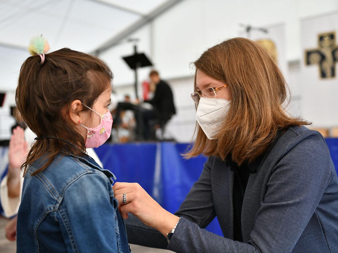 Die Schulleiterin hängte den Kindern eigens gesegnete Ketten mit Fischsymbol als Geschenk zum Schulbeginn um.