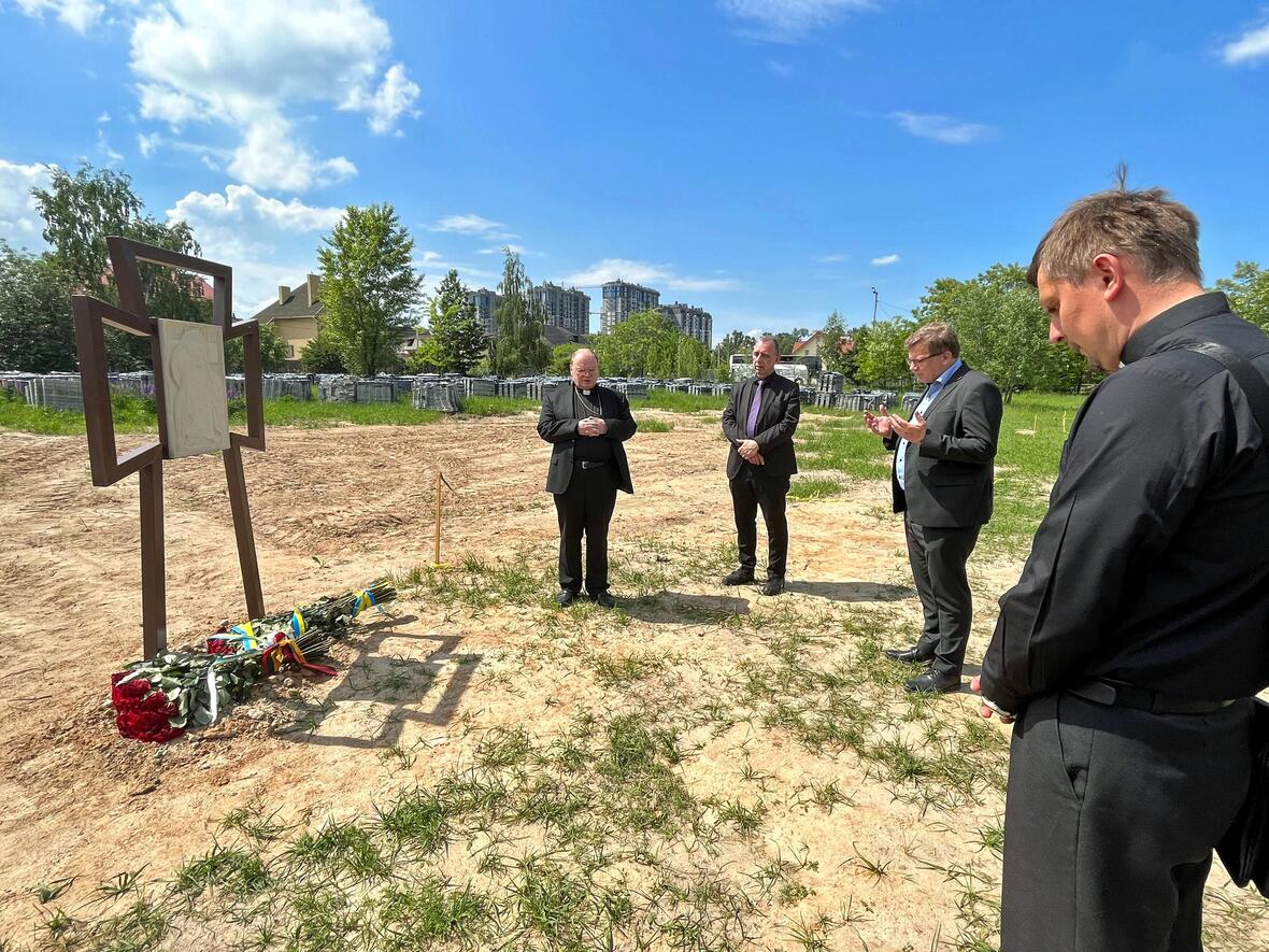 Bischof Bertram Meier gedenkt vor einem Massengrab der Opfer des Krieges.