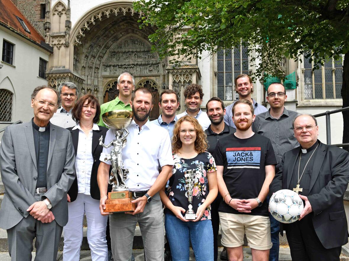 Die erfolgreichen Fußballer präsentierten ihre Pokale auf der Treppe vor dem Dom. Flankiert wurden sie dabei von Generalvikar Hacker (links) und Bischof Bertram (rechts). (Foto: Nicolas Schnall / pba)