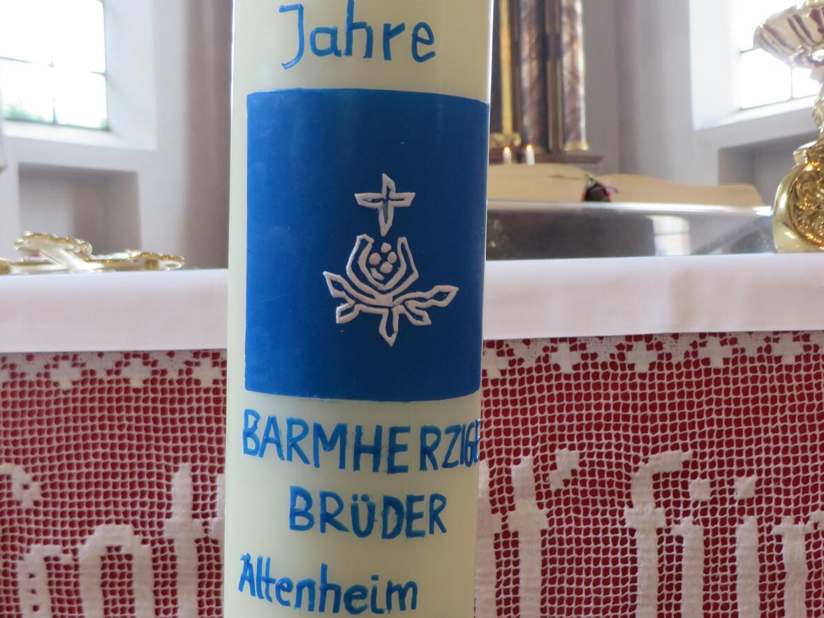 Bischof Bertram überreichte den Barmherzigen Brüdern eine Jubiläumskerze mit dem Ordenssymbol, dem Granatapfel.