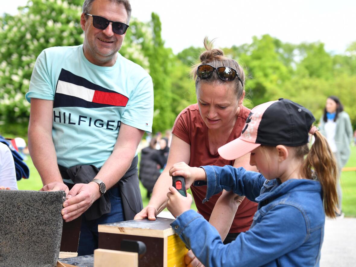 Bis aus Waltenhofen im Allgäu kam diese Familie zum Kinderfest nach Augsburg. Gemeinsam bastelten sie ein Vogelhäuschen. (Foto: Maria Rösch / pba)
